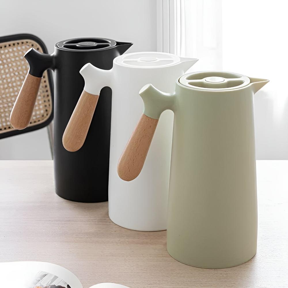 Three ceramic hot water bottles with wooden handles on a light surface.