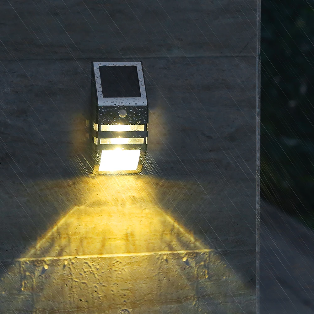 Solar-powered outdoor light fixture on a wall with a beam of light directed downwards.