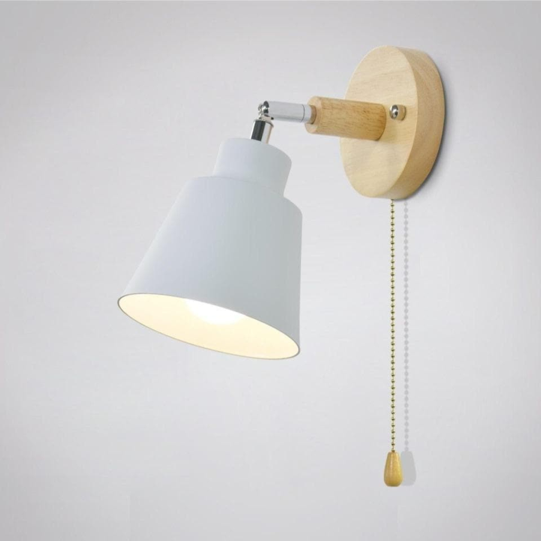 Wall-mounted light fixture with white shade and wooden arm on a plain background