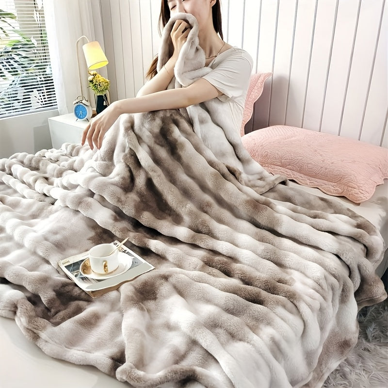 Person wrapped in a fluffy blanket in a cozy room with a pink pillow and small table.
