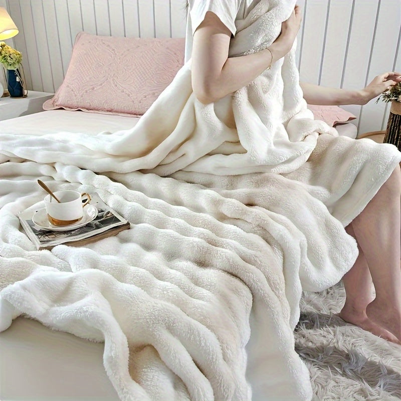 Person wrapped in a fluffy white blanket on a bed with a cup and saucer on a small table.