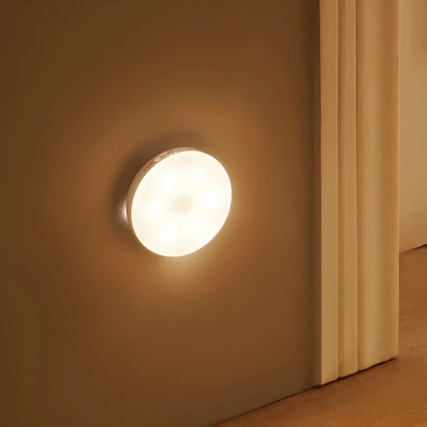 Round wall light fixture on a beige wall with a white base.