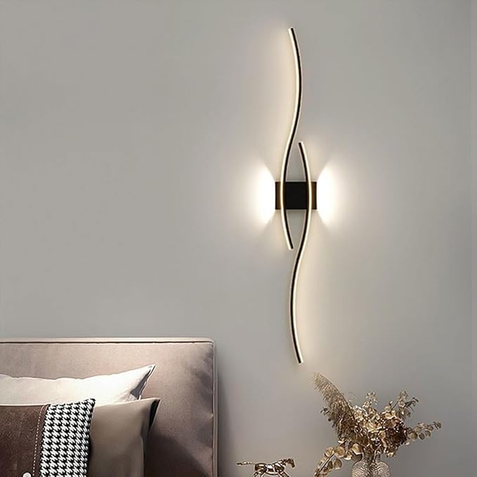 Modern wall lamp on a gray wall with a bed and decorative elements in the foreground