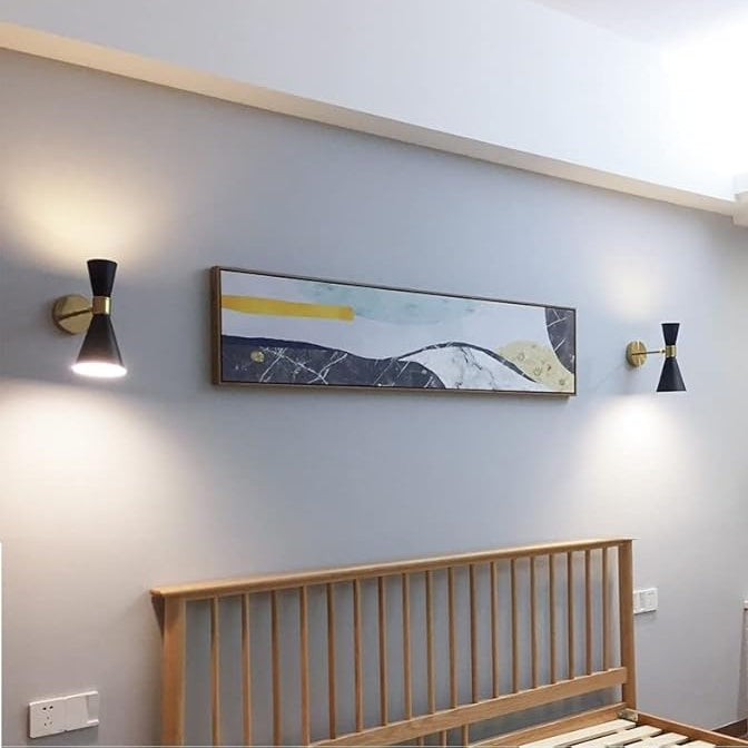 Modern bedroom interior with abstract wall art, wooden headboard, and wall lights.