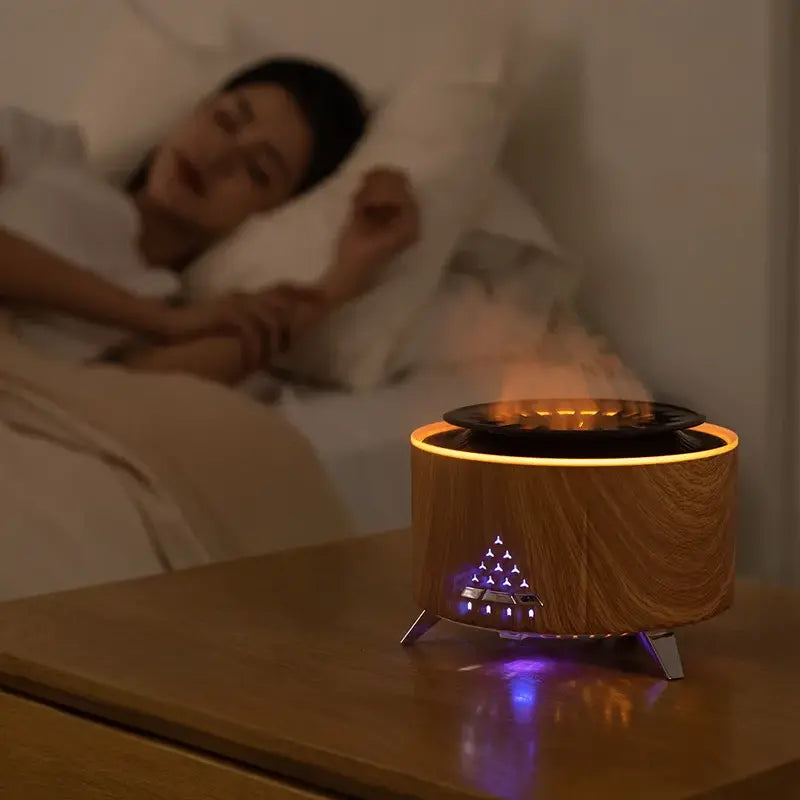 Small fire pit on a nightstand with a person lying in bed in the background