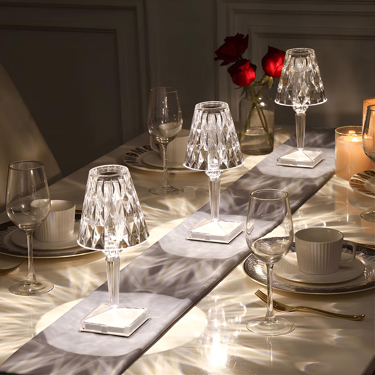 Dining table set with crystal glasses, cups, and a vase of red roses.