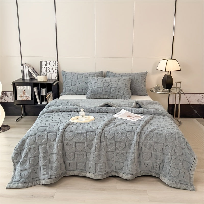 Gray textured bedspread with heart and 'LOVE' patterns on a bed in a bedroom setting.