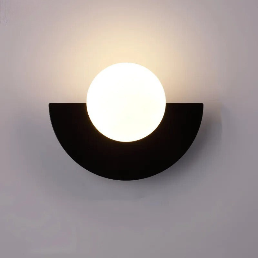 Wall-mounted light fixture with a black semi-circular base and white circular light bulb on a gray background
