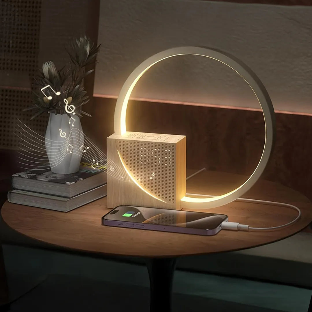 Modern desk setup with a circular LED lamp, smartphone, and books on a wooden surface.