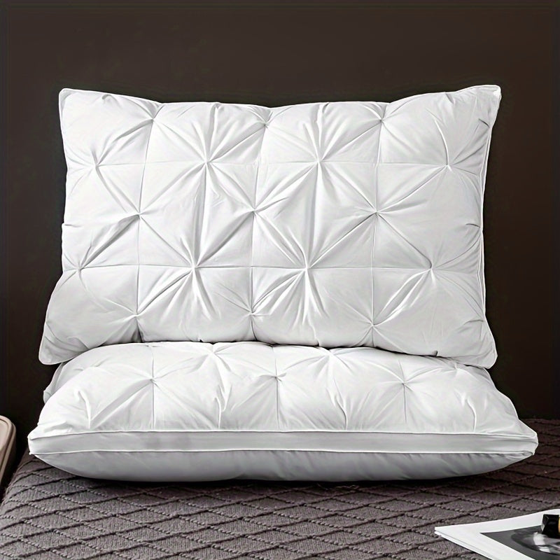 Two white quilted pillows on a textured surface with a dark background