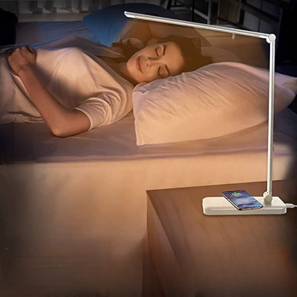 Woman sleeping in bed with a night light on a bedside table.