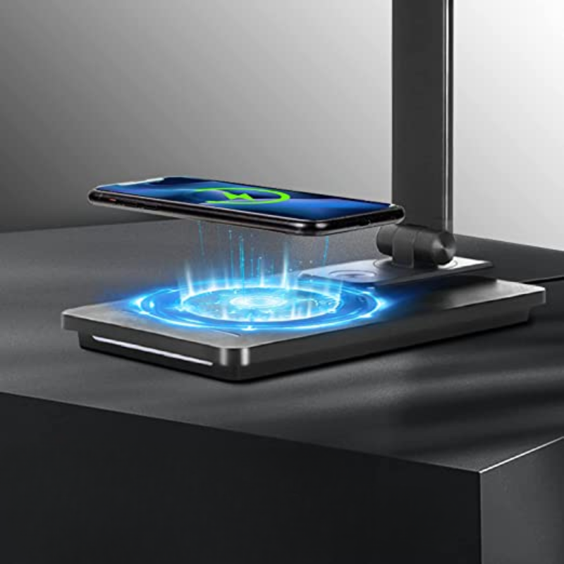 Wireless charging pad with a phone levitating above it on a dark surface.