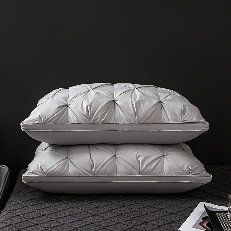 Two gray pillows stacked on a textured surface with a dark background