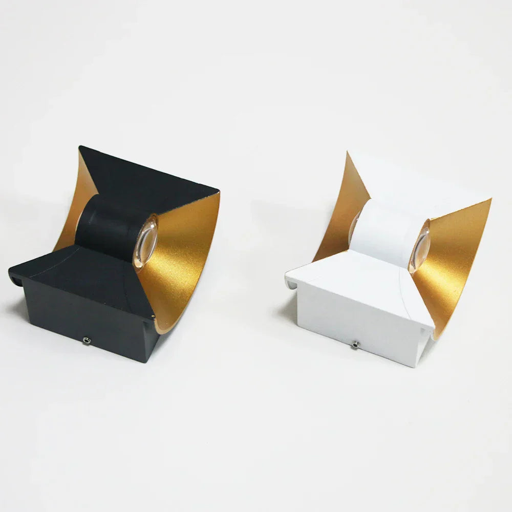 Two decorative boxes, one black and gold, the other white and gold, on a light gray background.