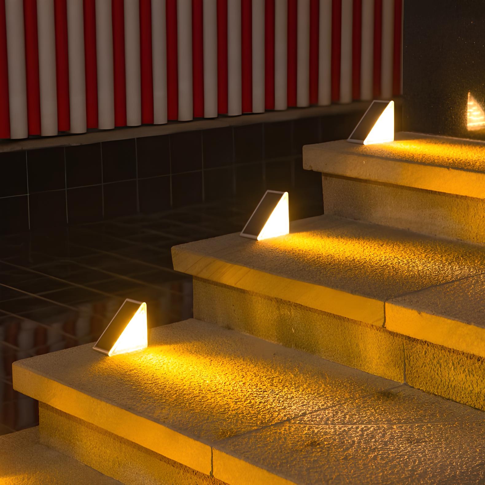 Stair lights illuminating steps with a red and white striped awning in the background