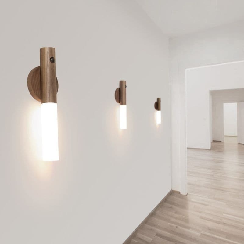 Wooden wall sconces on a white wall with a light on, in a minimalistic room.