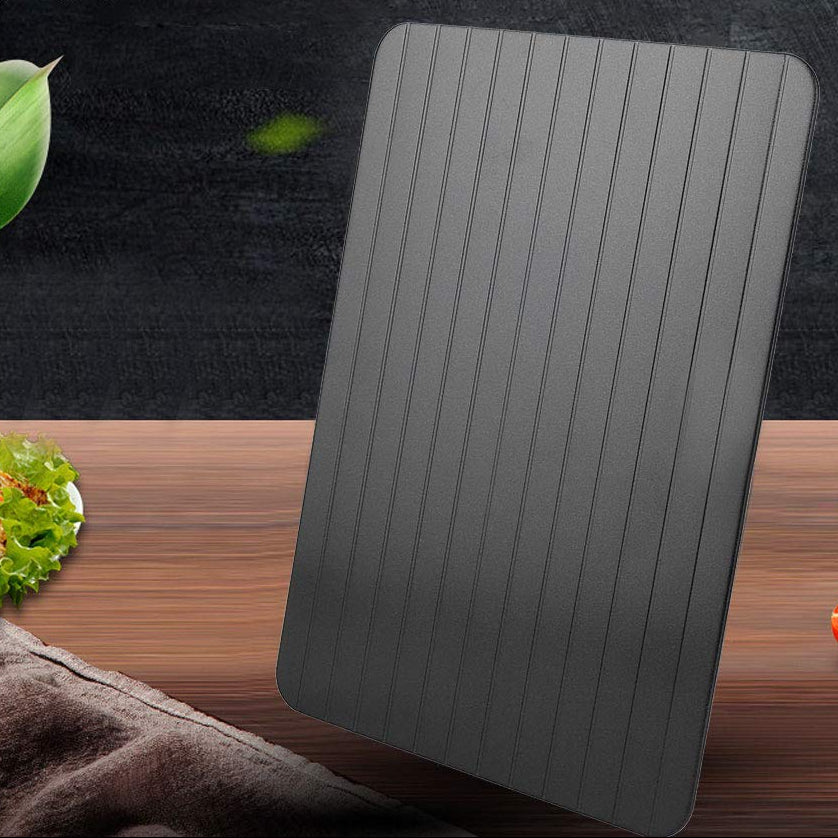 Defrosting tray on a wooden surface with vegetables, text indicating ease of use and environmental benefits.