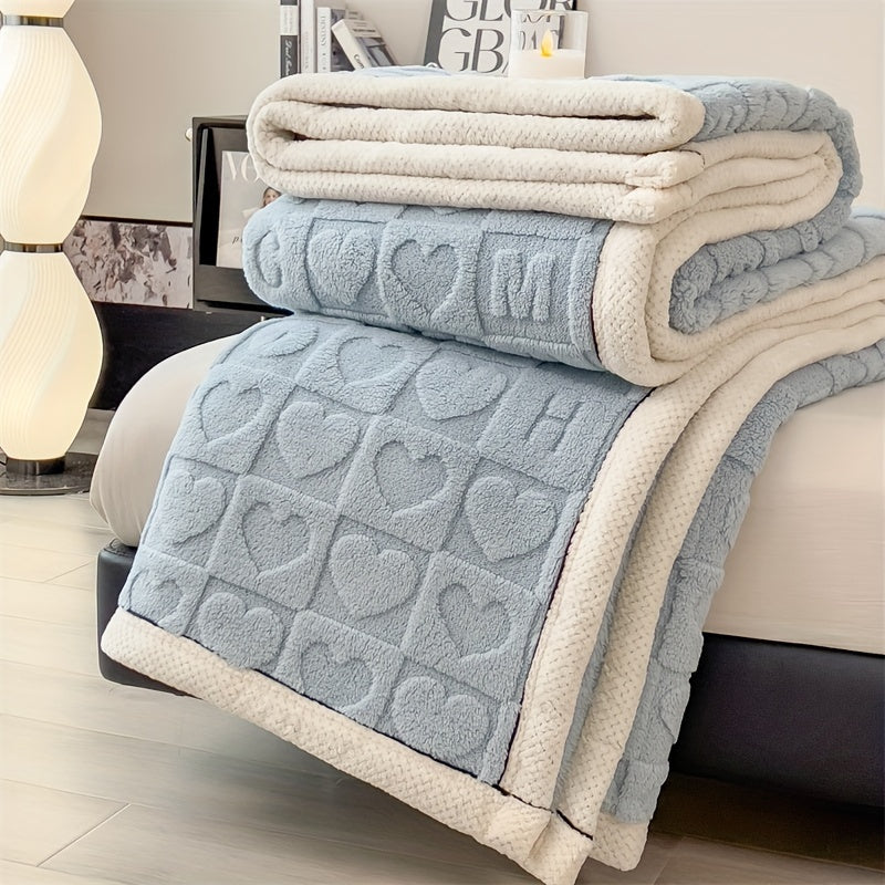 Stack of textured towels with heart patterns on a bed in a bedroom setting