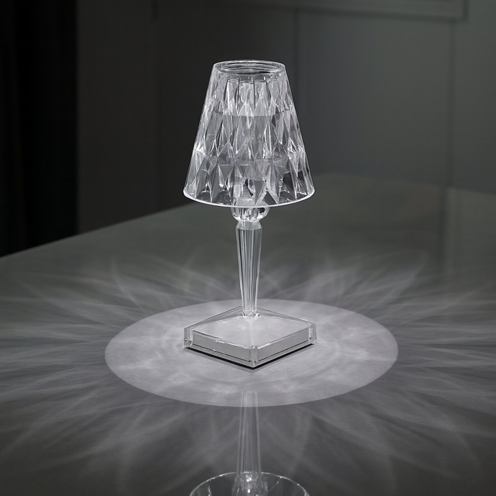 Clear glass table lamp on a dark surface with a soft light effect