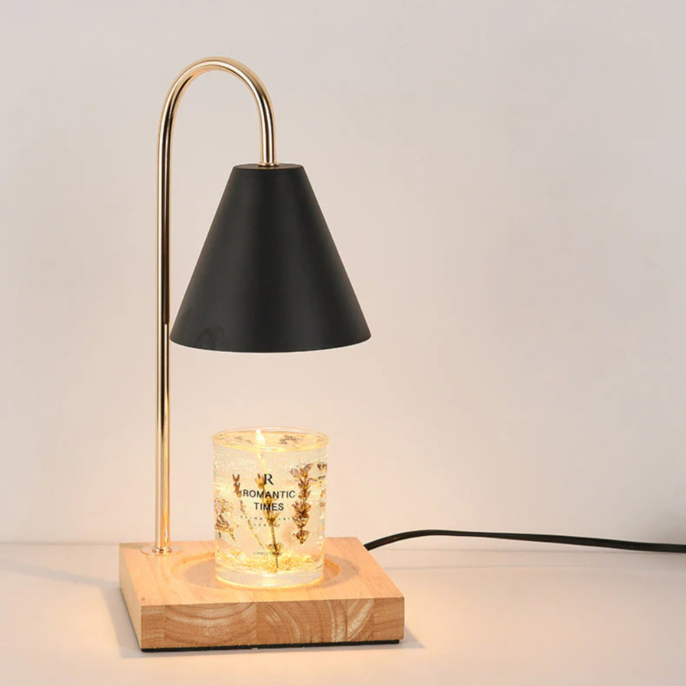 Table lamp with black shade and wooden base holding a lit candle on a neutral background
