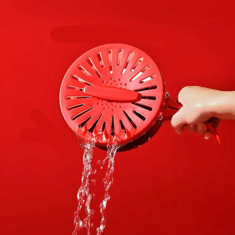 Red shower head with water flowing, held by a hand against a red background