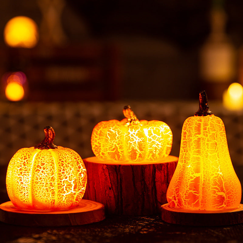 Three illuminated pumpkin-shaped lamps on a dark background with blurred lights.