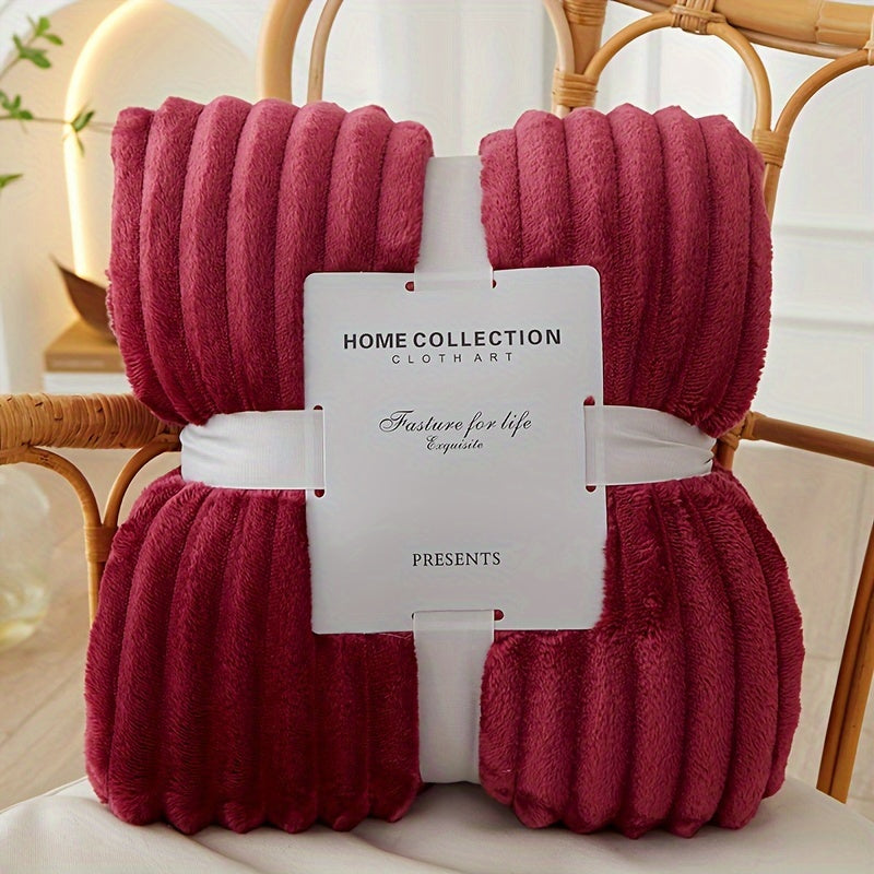 Red textured throw blanket with a brand tag on a chair