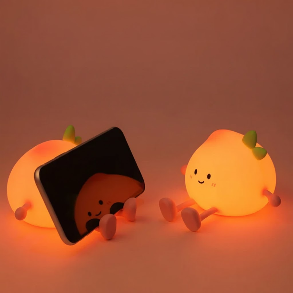 Two cute, glowing orange character lamps on a warm-toned background