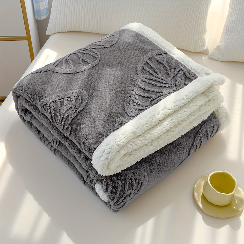 Gray blanket with leaf patterns on a white surface