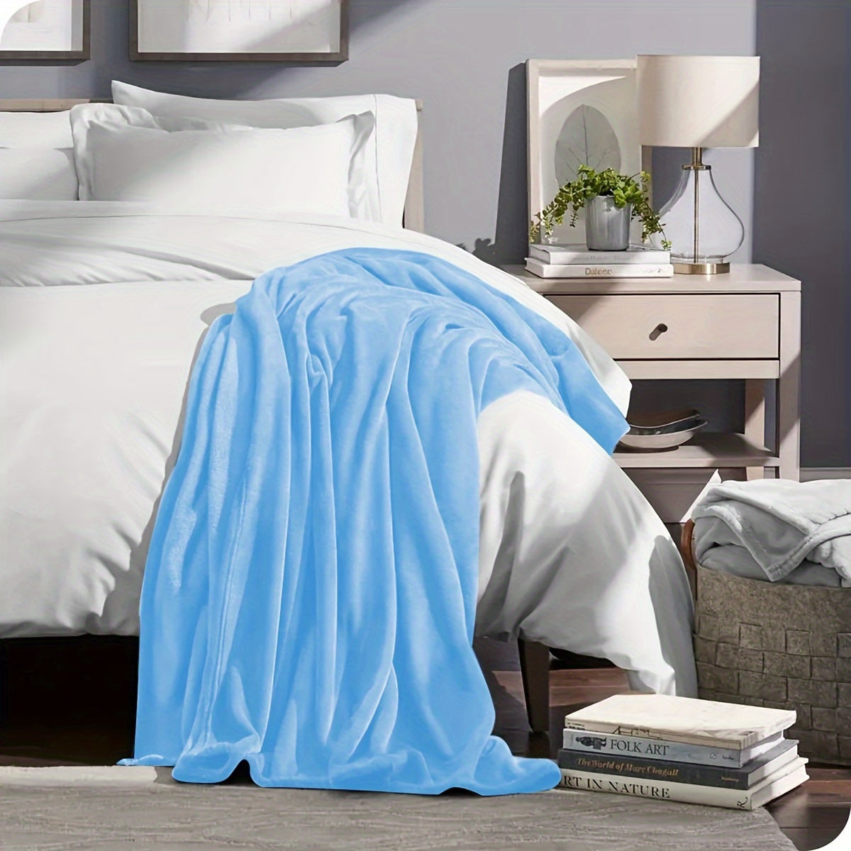 Blue blanket draped over a bed in a bedroom setting with a nightstand and lamp.
