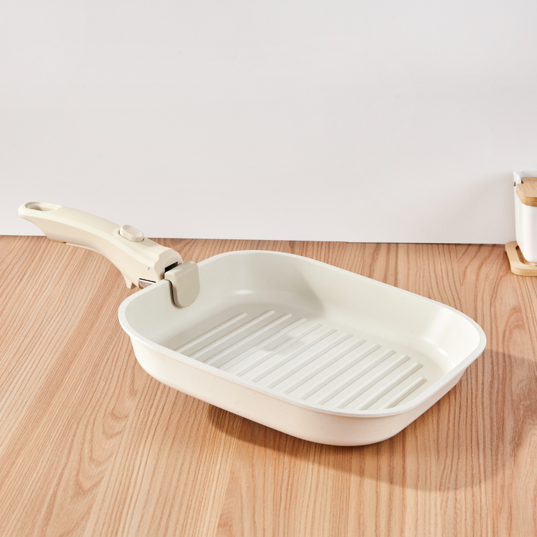 White ceramic grill pan with handle on a wooden surface