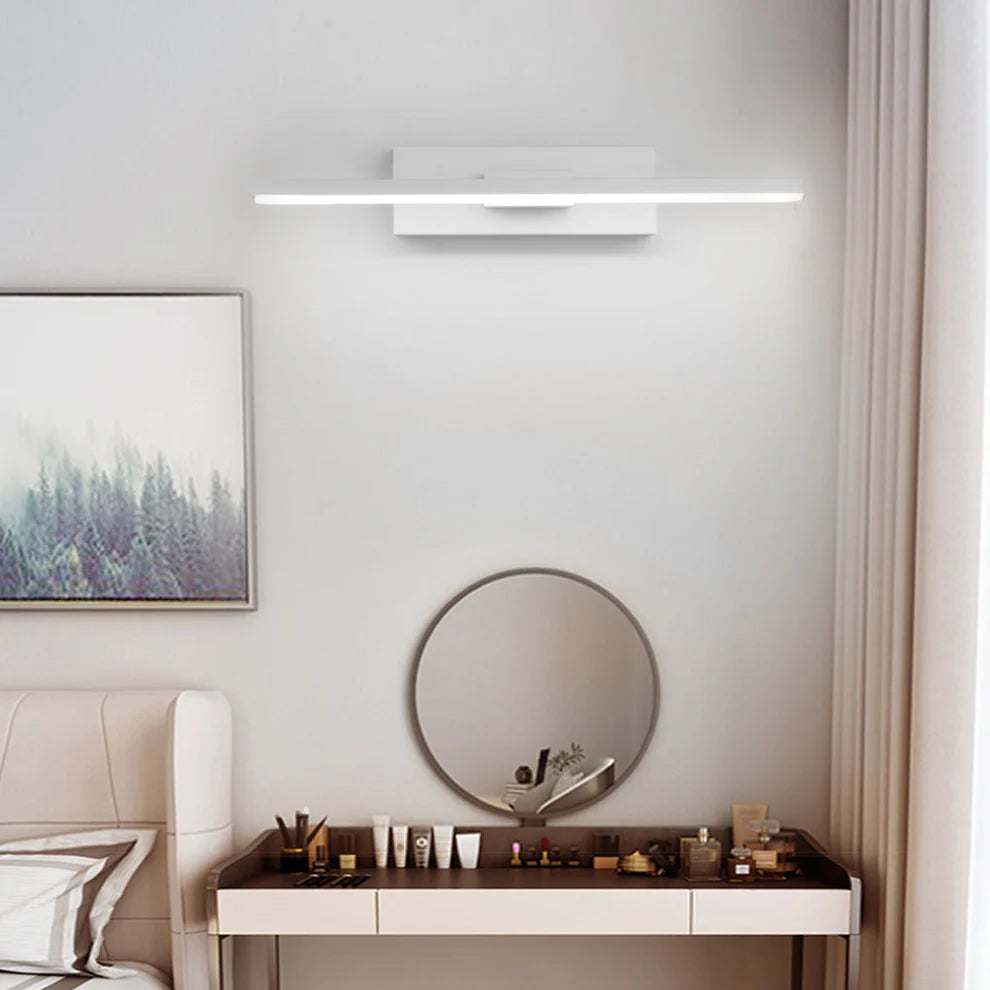 Modern bedroom with round mirror, nightstand, and wall-mounted light fixture.