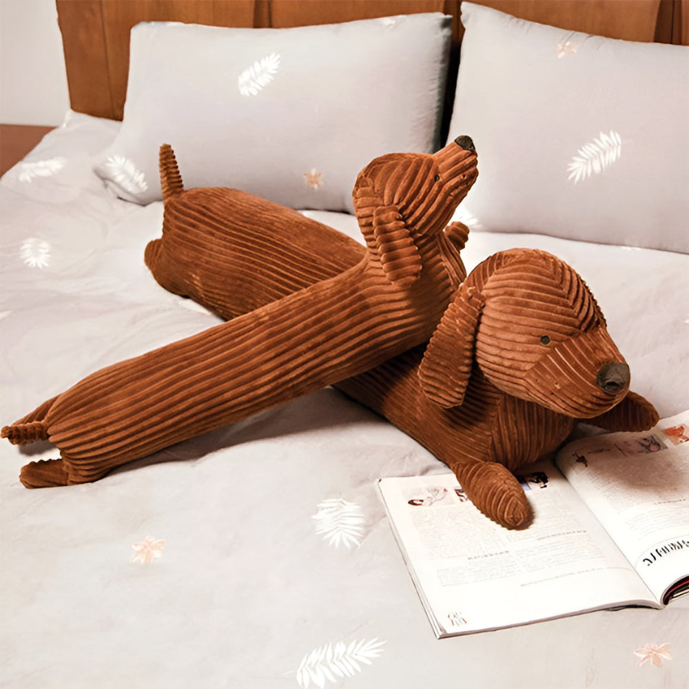Brown plush dog toy on a bed with an open book