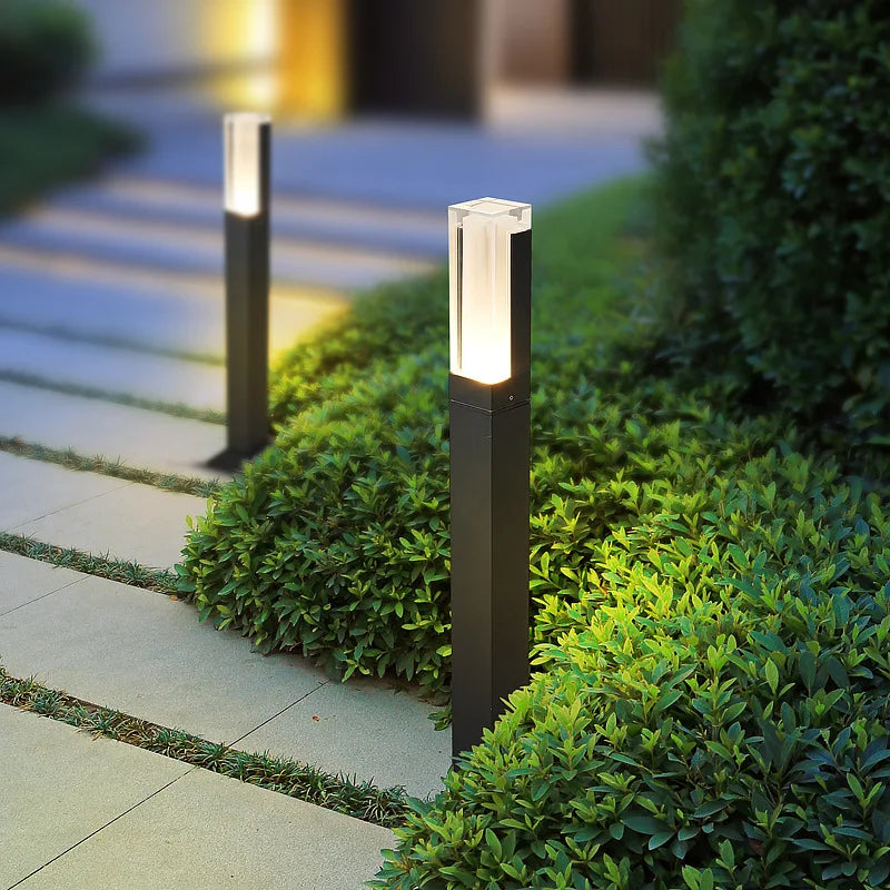 Decorative outdoor lights on a garden path with greenery.