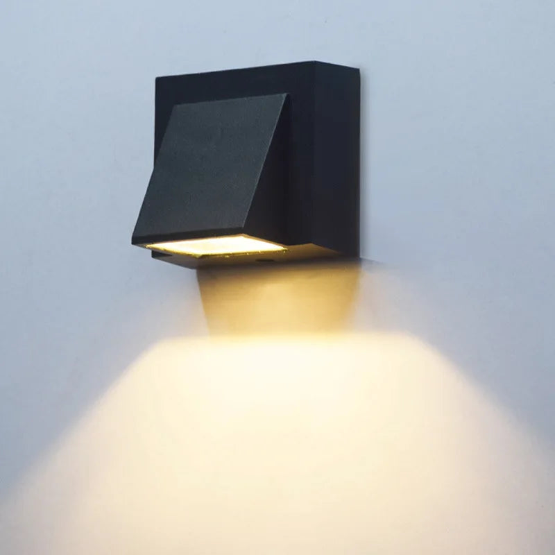 Black outdoor wall light fixture on a light gray wall