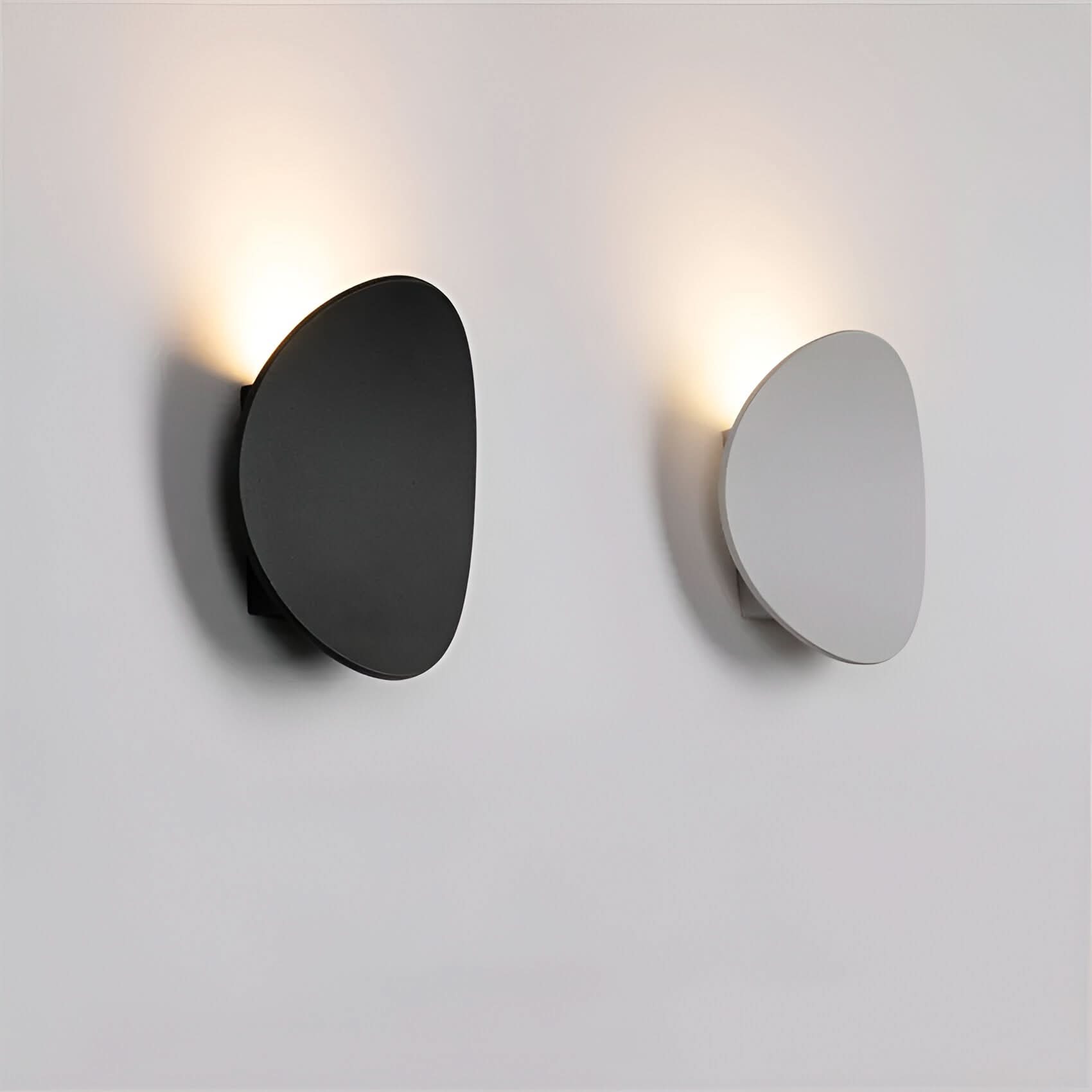 Two wall lights, one black and one silver, on a light gray background.