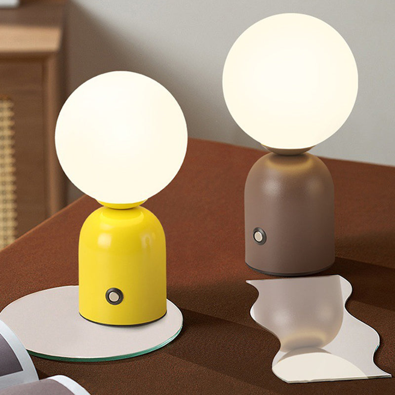 Two small table lamps, one yellow and one brown, on a reflective surface.