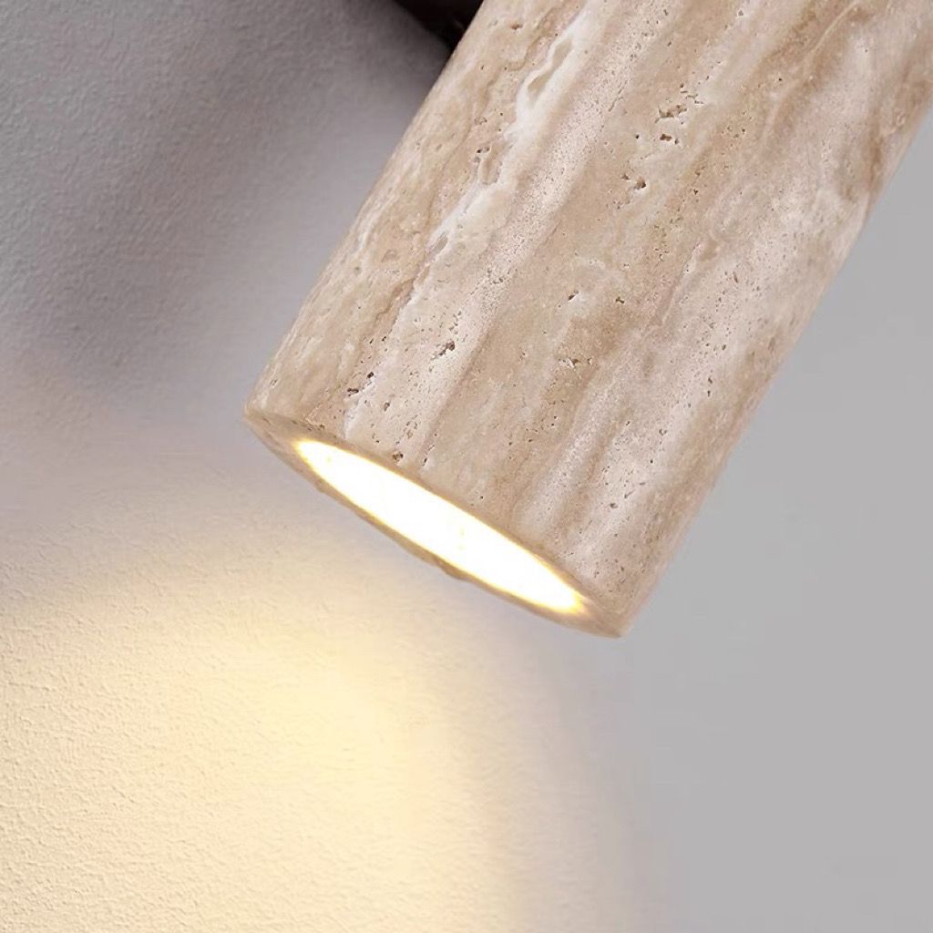 Beige cylindrical light fixture on a gray wall
