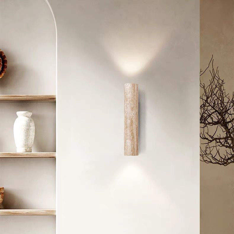 Cylindrical wall light fixture on a neutral wall with minimal decor