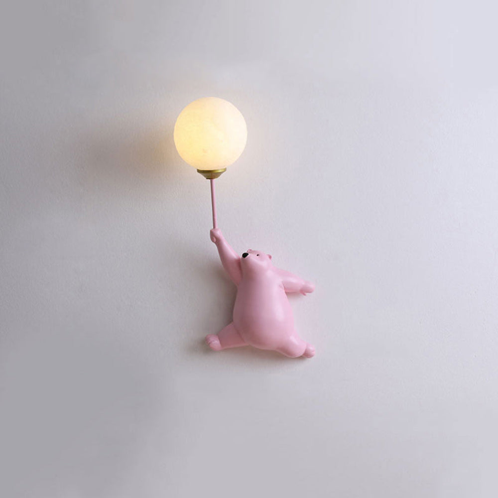 Pink bear toy with a balloon-shaped light on a plain background