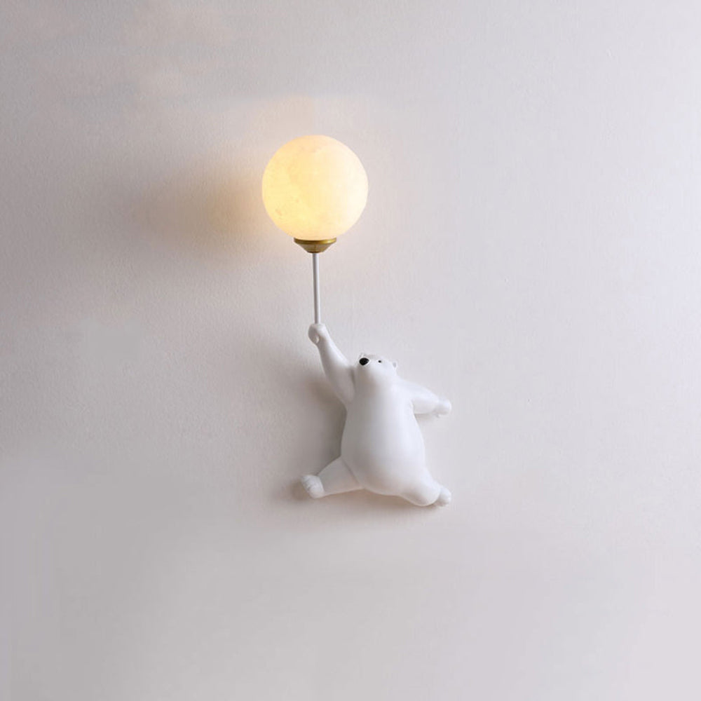 Wall lamp shaped like a polar bear holding a light bulb on a plain wall.