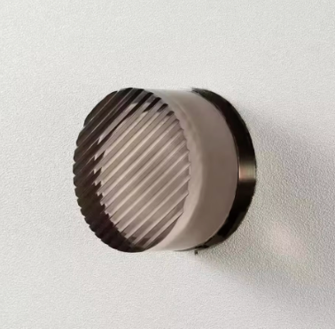 Round metallic filter on a light gray background