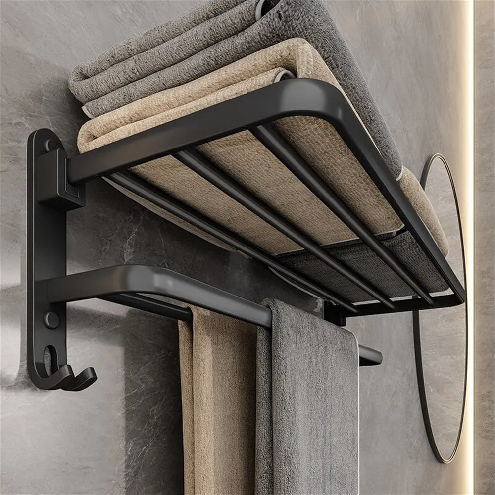 Black towel rack with folded towels on a gray wall