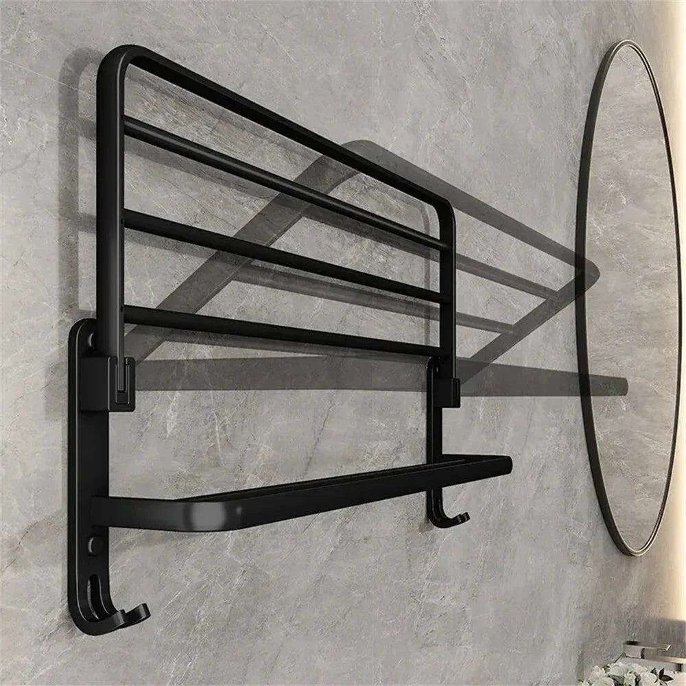 Black towel rack mounted on a gray tiled wall with a round mirror.