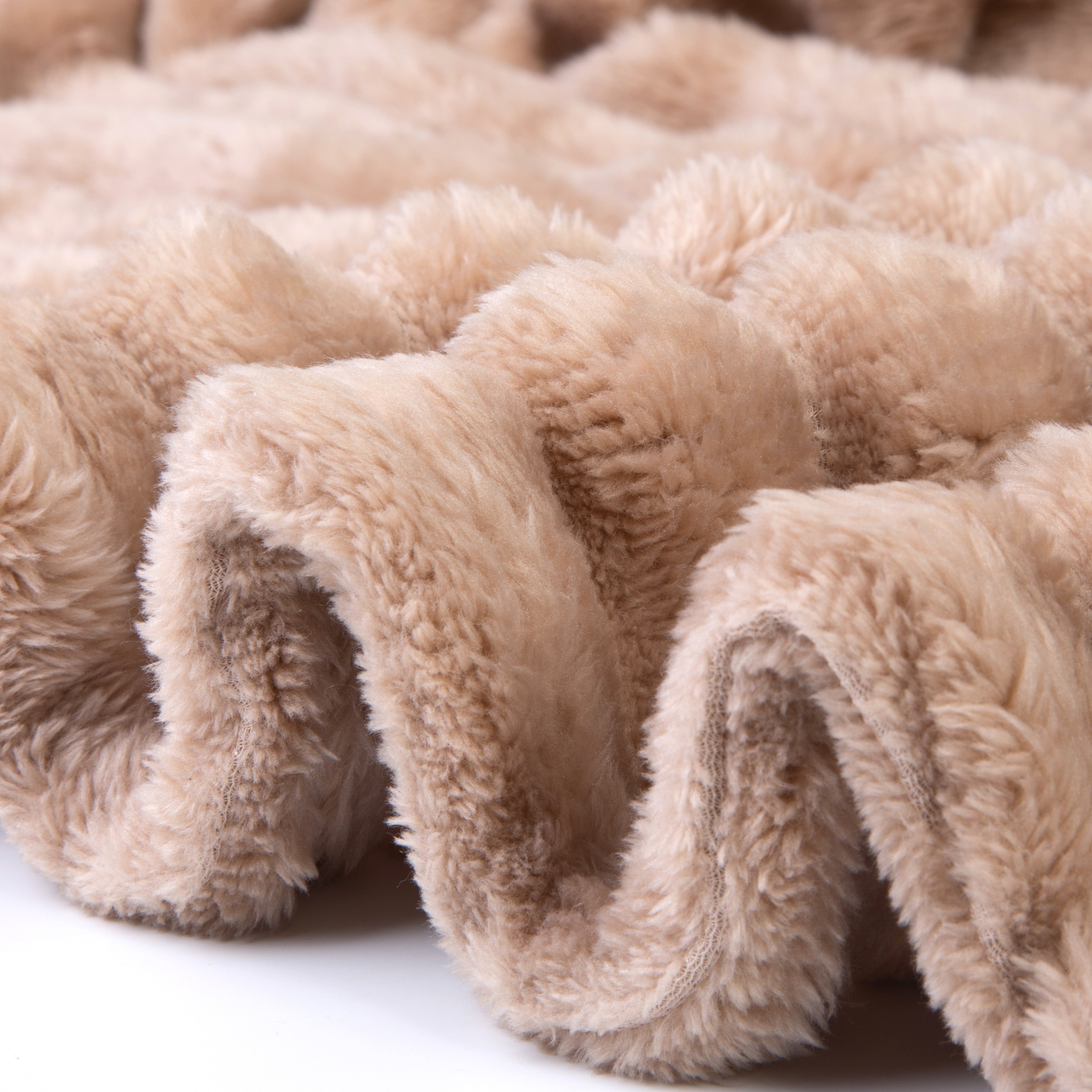 Close-up of beige plush blanket with soft texture