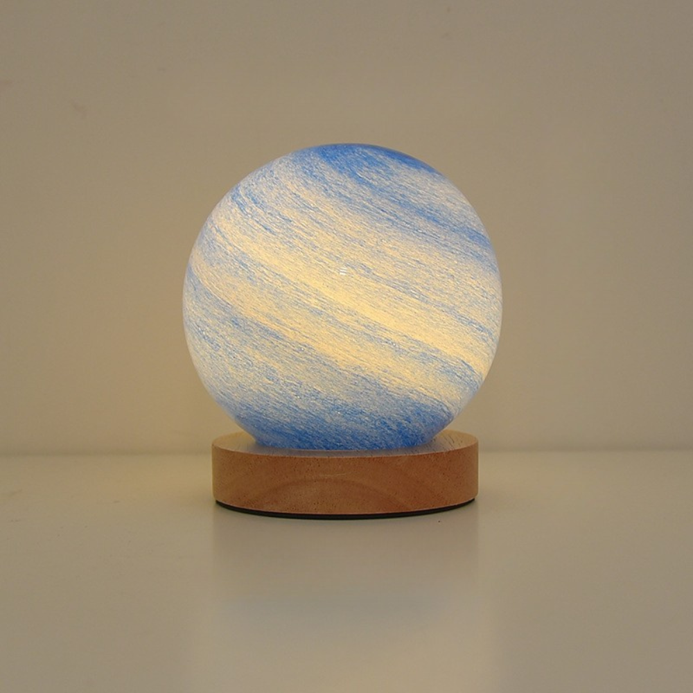 Spherical lamp with blue and white striped design on a wooden base against a plain background