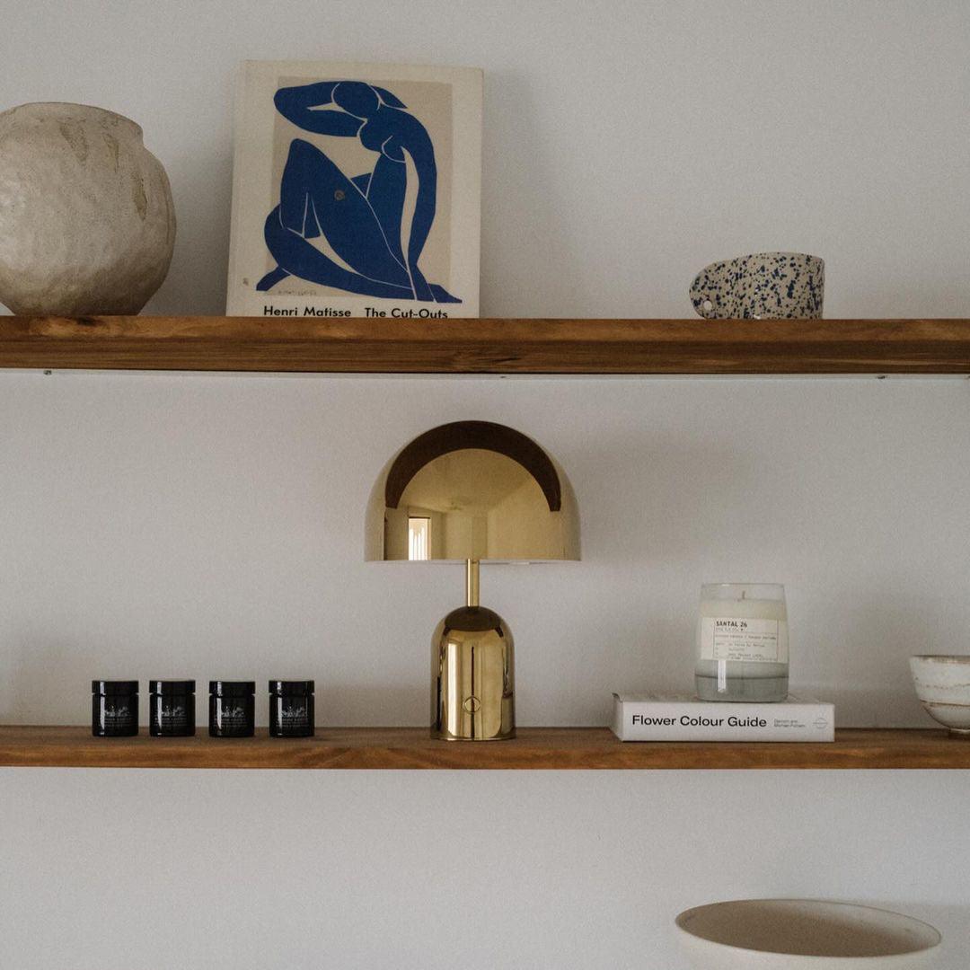 Wooden shelves with decorative items including a lamp, candles, and a framed artwork.
