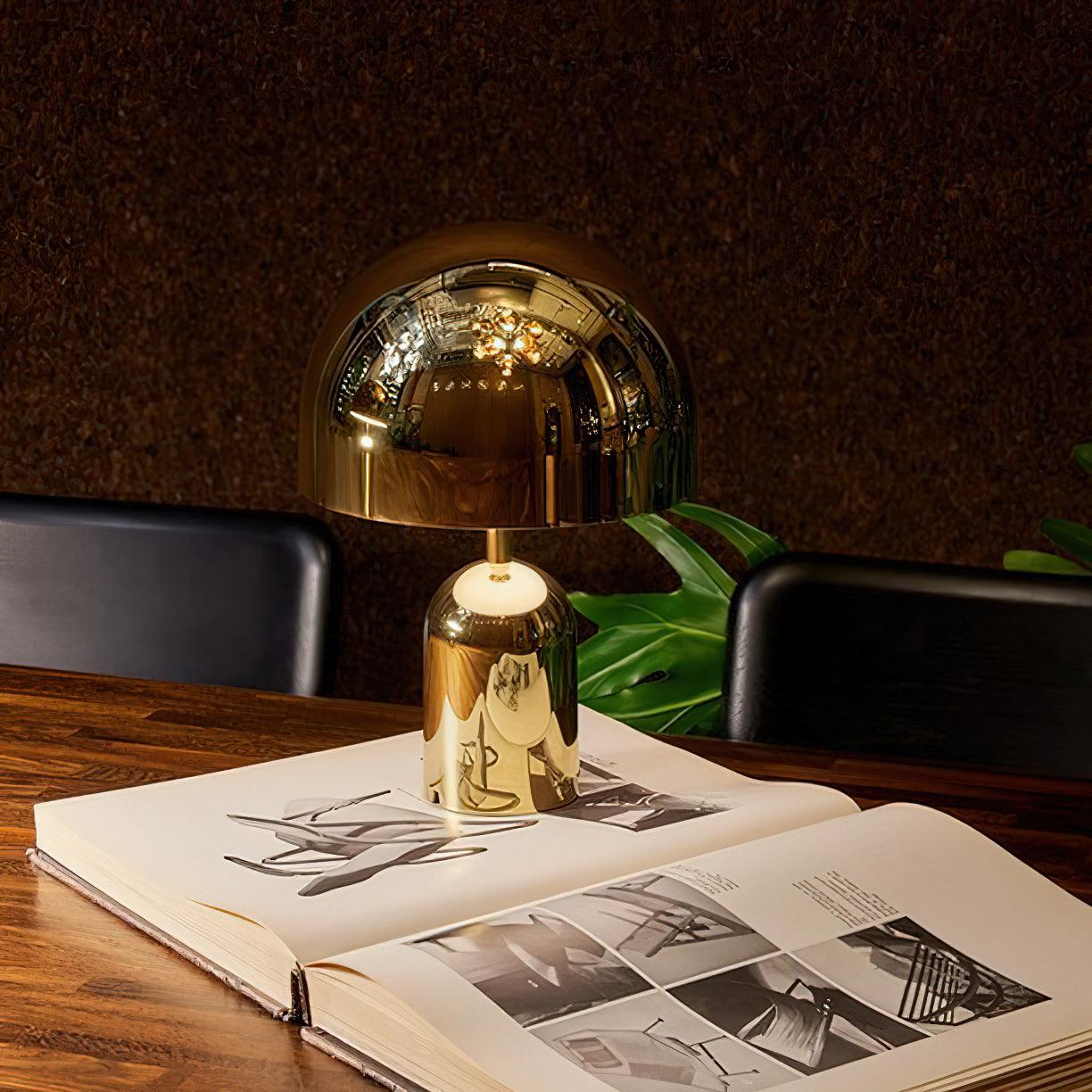 Gold table lamp on an open book with a dark background