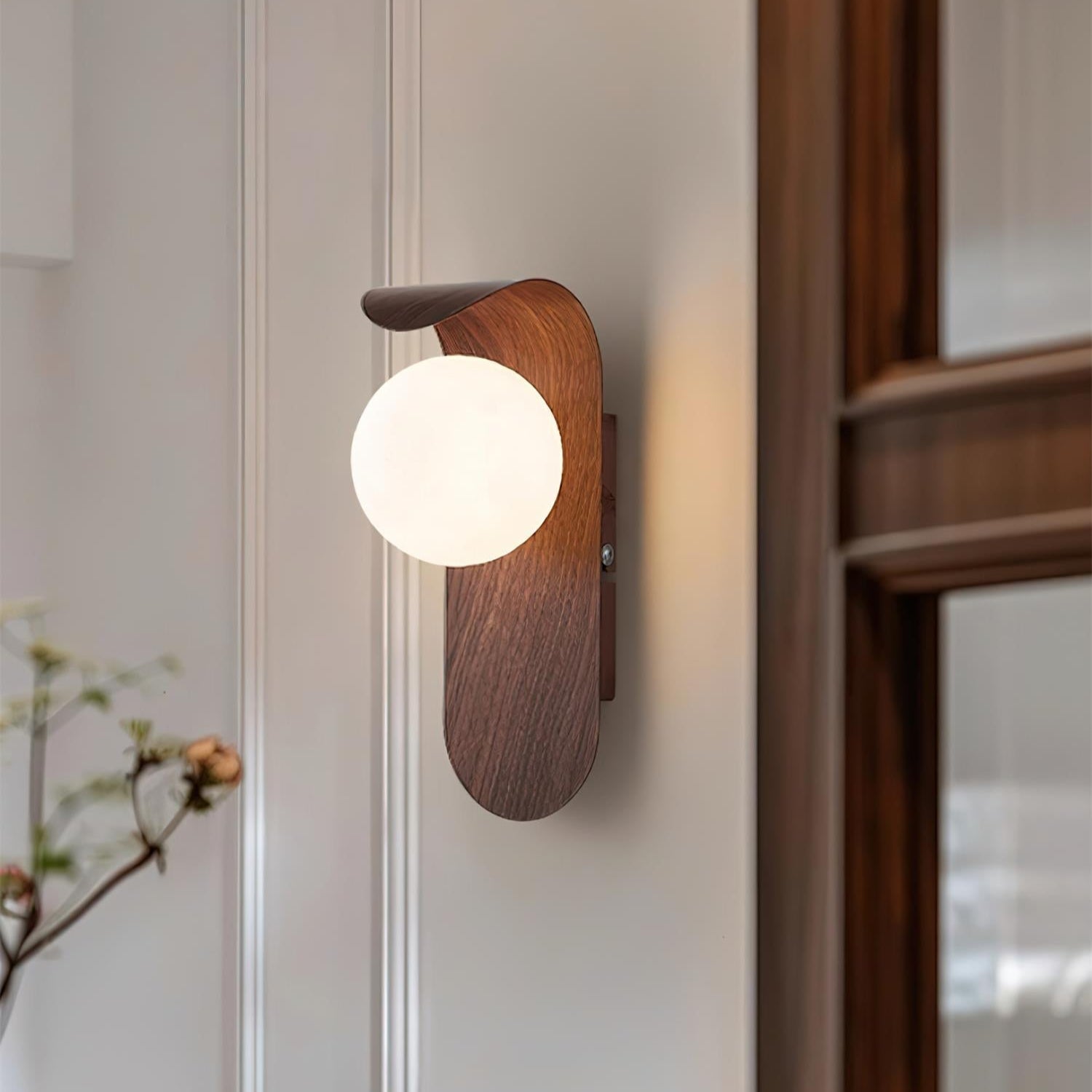 Wooden wall sconce with a round light bulb on a neutral wall.