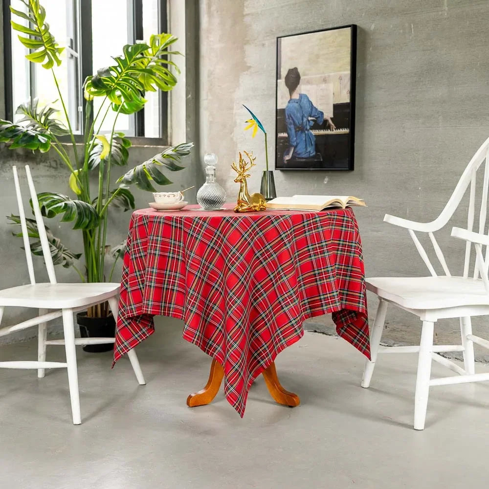 Red plaid tablecloth on a wooden table with white chairs and decorative items in a room.